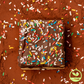 Veganer Cookie Brownie auf Kakaopulver und bunten Zuckerstreuseln
